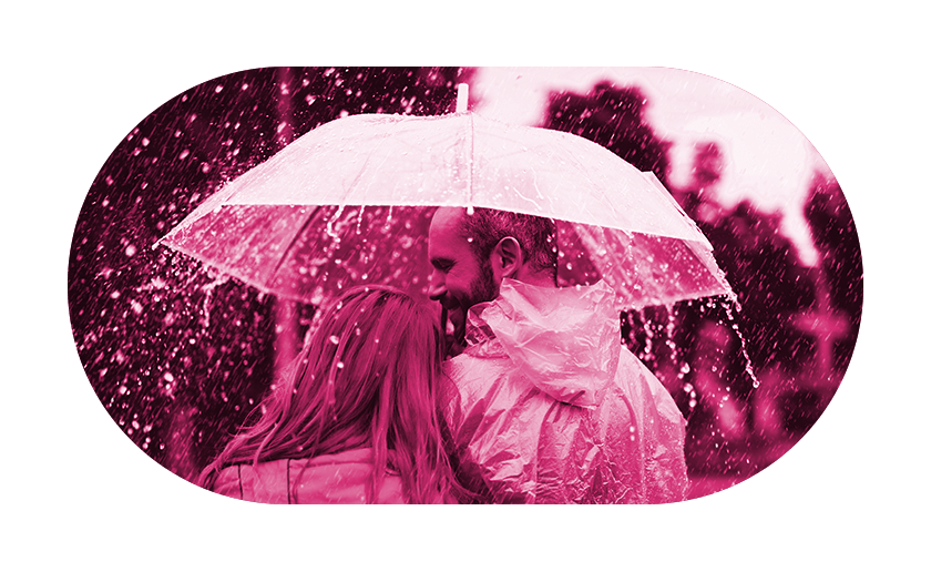 Man and woman under umbrella looking content in the rain